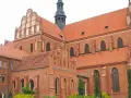 Gotycka katedra w Pelplinie, dawniej część kompleksu zamkowego, z charakterystycznymi ceglanymi murami i czerwonymi dachami.