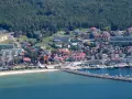 Widok na nadmorskie miasto Hel z portem, plażą i zabudowaniami.