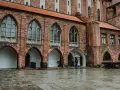 Zamek w Kwidzynie zaprasza. W deszczowy dzień zwiedzający z parasolem podziwiają gotycką architekturę. Bilety dostępne online.