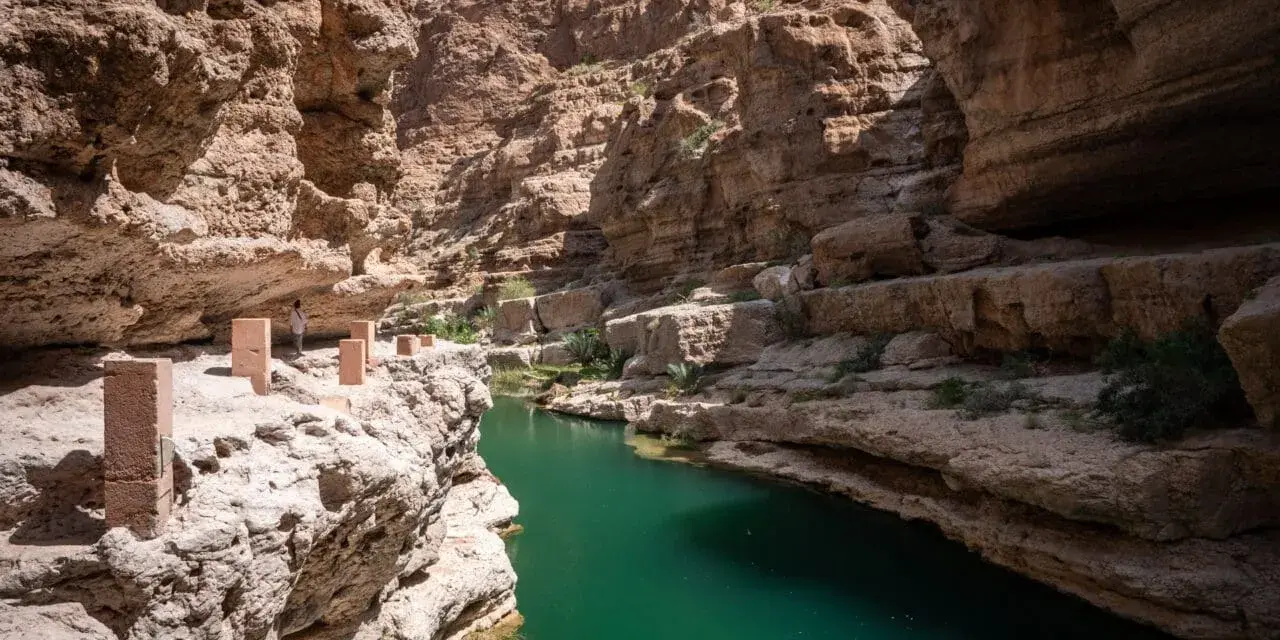 Wadi Shab w Omanie, z turkusową wodą i skalnymi ścianami, to jedna z wielu atrakcji tego kraju. Oman ciekawostki.