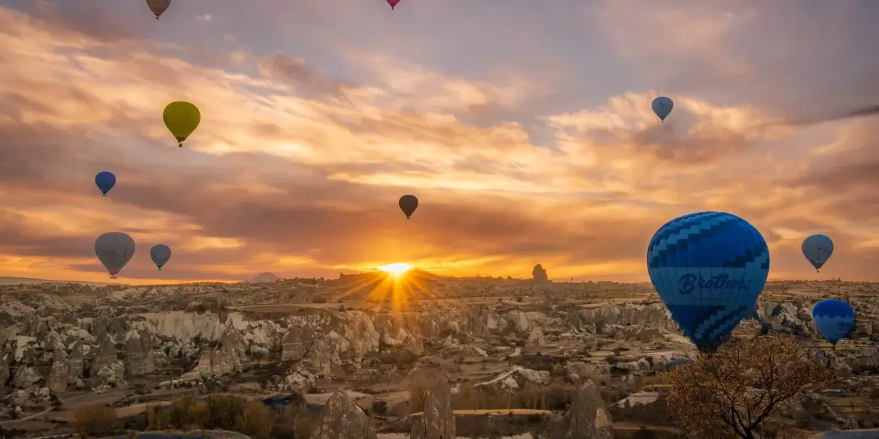 Balony unoszą się nad skalistym krajobrazem Kapadocji, tworząc magiczny widok. To miasto w skale w Turcji budzi zachwyt.