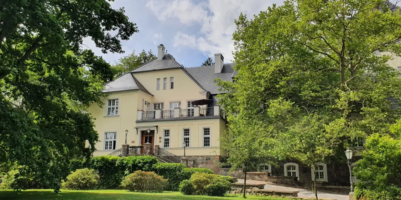 Pałac Ciekocinko, otoczony zielenią, skrywa bogatą historię. Jasna fasada i kamienne detale świadczą o jego przeszłości.