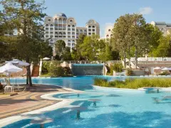 Basen z wodospadem i leżakami przy hotelu Riu Helios Paradise. Idealne miejsce na relaks.