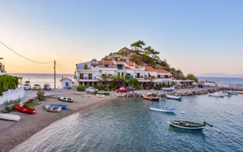 Widok na zatokę Vathy na Samos z łodziami i budynkami na tle wzgórza.