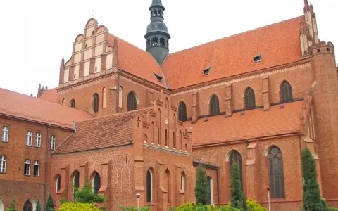 Gotycka katedra w Pelplinie, dawniej część kompleksu zamkowego, z charakterystycznymi ceglanymi murami i czerwonymi dachami.