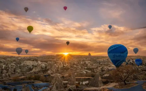 Balony unoszą się nad skalistym krajobrazem Kapadocji, tworząc magiczny widok. To miasto w skale w Turcji budzi zachwyt.