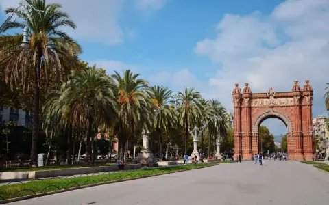 Łuk Triumfalny w Barcelonie, z rzędem palm i błękitnym niebem, to ikoniczne miejsce, które podkreśla wspaniałe barcelona położenie.
