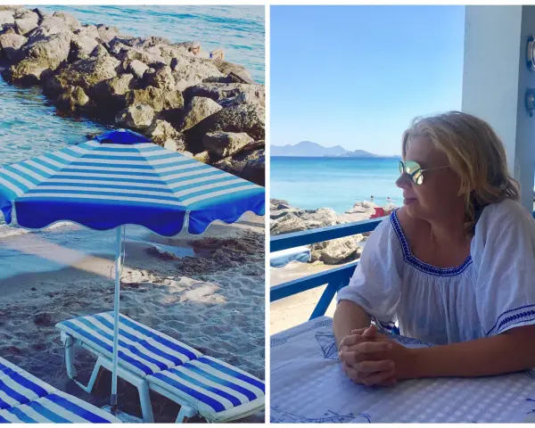 Słońce, plaża i błękitne morze – idealne wakacje na Kos w Grecji. Kobieta w okularach przeciwsłonecznych relaksuje się przy stoliku z widokiem na wybrzeże.