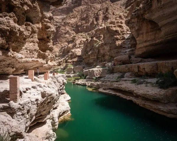 Wadi Shab w Omanie, z turkusową wodą i skalnymi ścianami, to jedna z wielu atrakcji tego kraju. Oman ciekawostki.