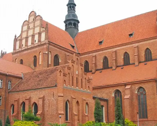 Gotycka katedra w Pelplinie, dawniej część kompleksu zamkowego, z charakterystycznymi ceglanymi murami i czerwonymi dachami.