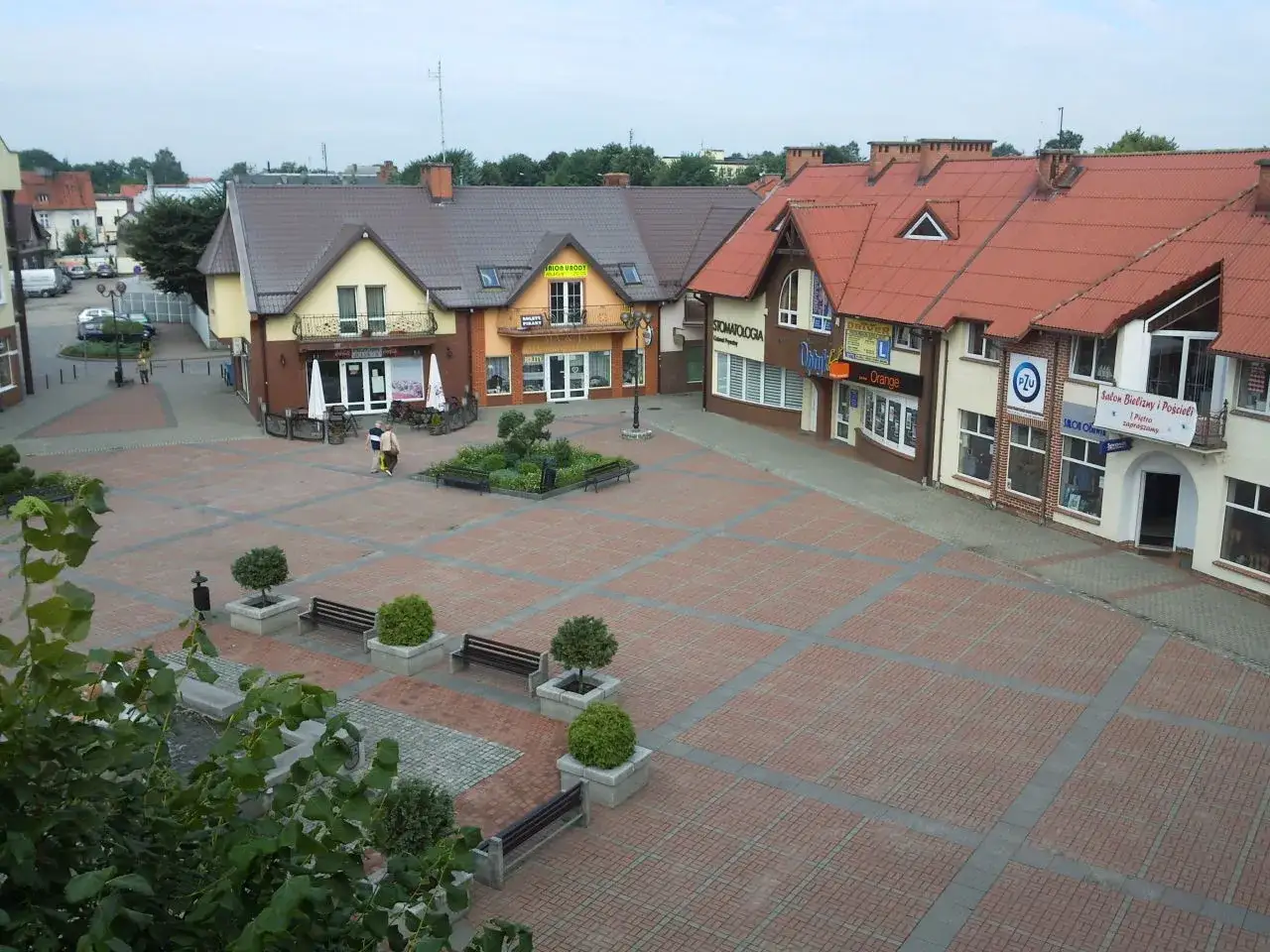 Rynek w Czersku z kamienicami i zielenią. Atrakcje miasta widoczne na placu.
