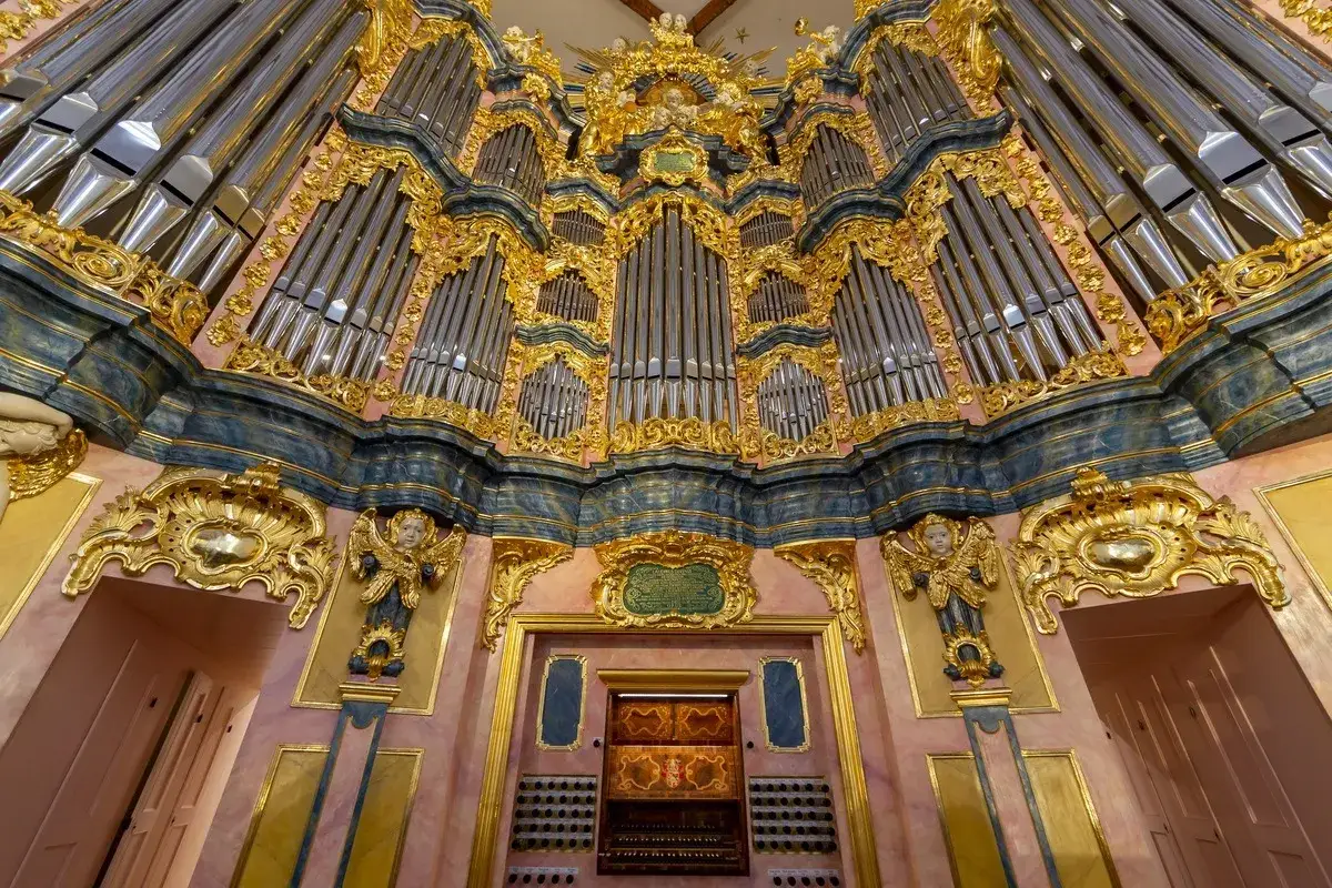 Majestatyczne organy w kościele św. Elżbiety we Wrocławiu, gotowe na koncert. Złote zdobienia i liczne piszczałki tworzą imponujący widok.