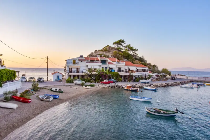 Widok na zatokę Vathy na Samos z łodziami i budynkami na tle wzgórza.
