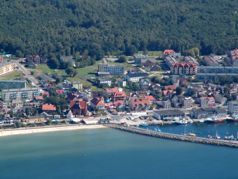 Widok na nadmorskie miasto Hel z portem, plażą i zabudowaniami.